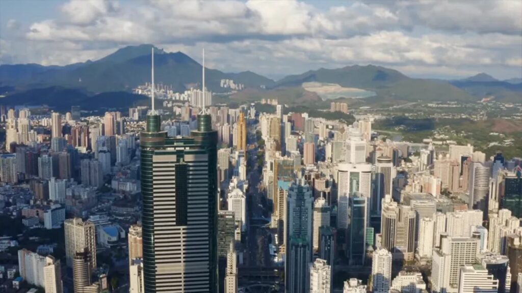 Aerial view of modern high-rise buildings and towers with mountains in the background