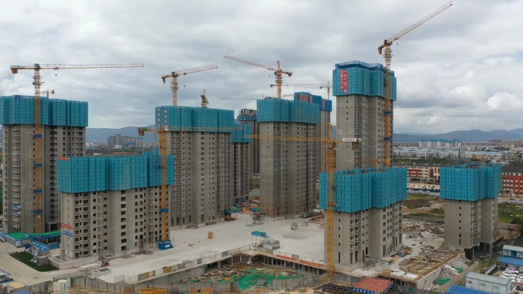 Aerial view of cranes and unfinished apartment towers at a large housing development in China