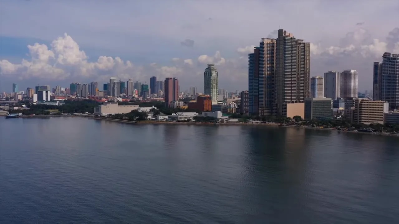 Riverfront skyline with tall buildings and cloudy sky