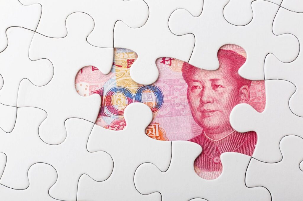 puzzle pieces revealing a chinese yuan banknote s