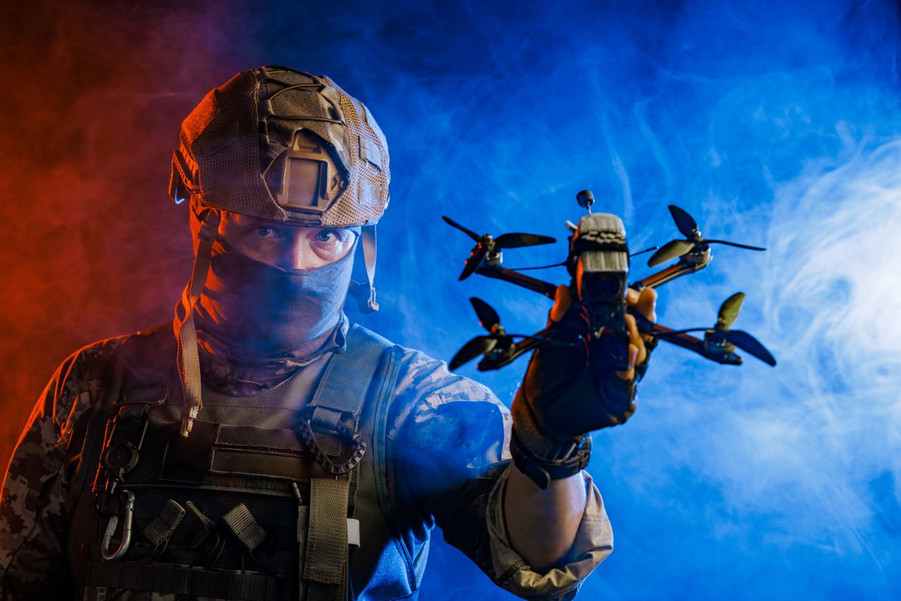 soldier holding a drone in a simulated war zone s