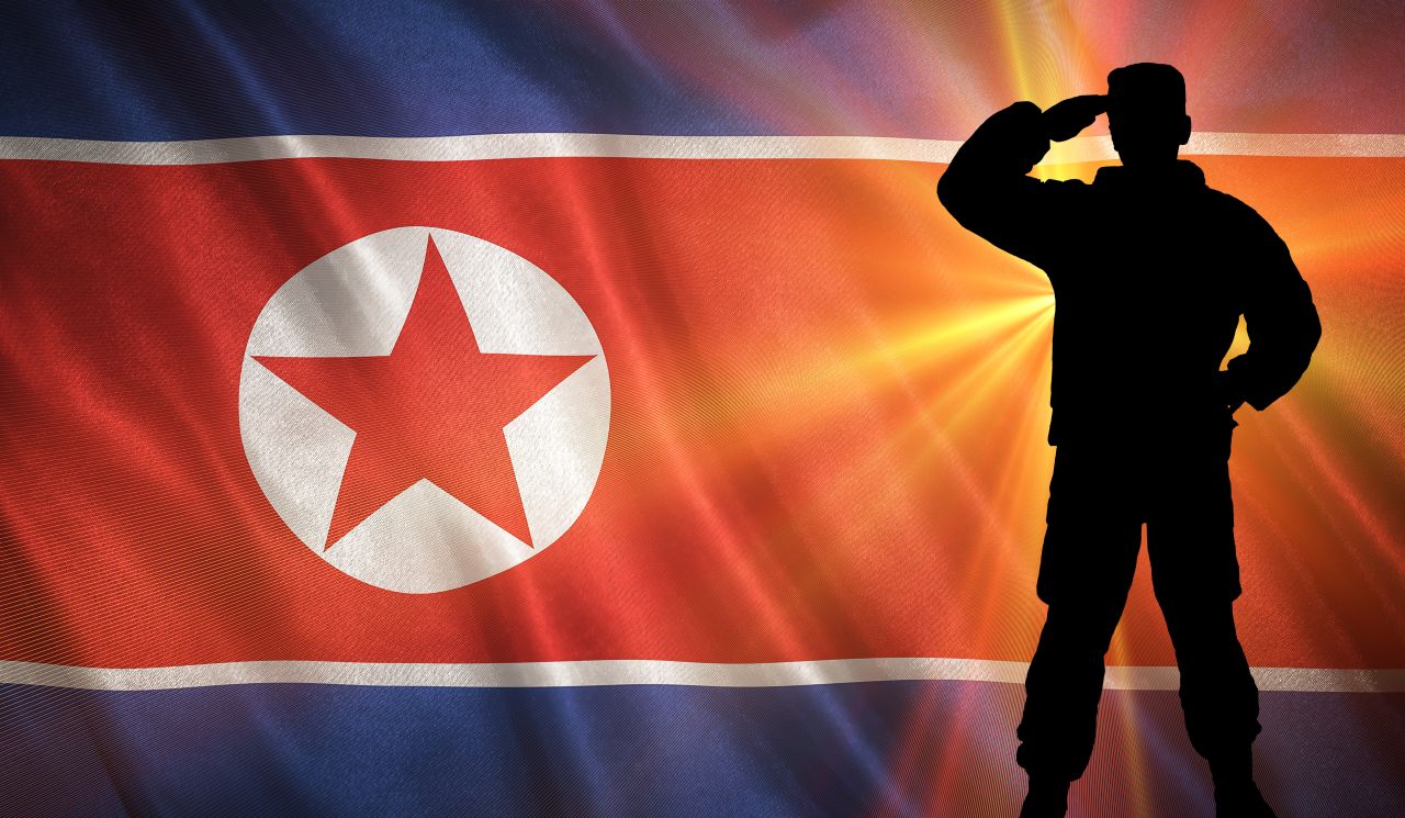 soldier silhouette saluting in front of flag north korea s