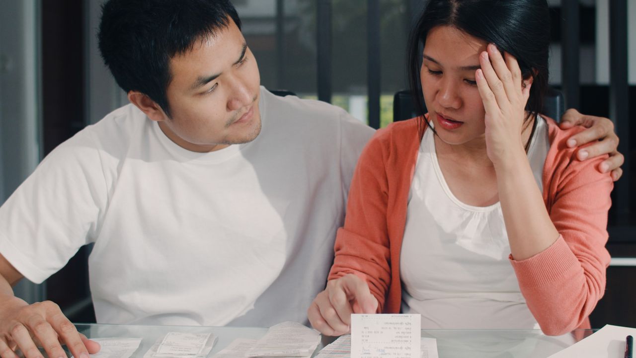 worried couple looking at bills at table indoors s