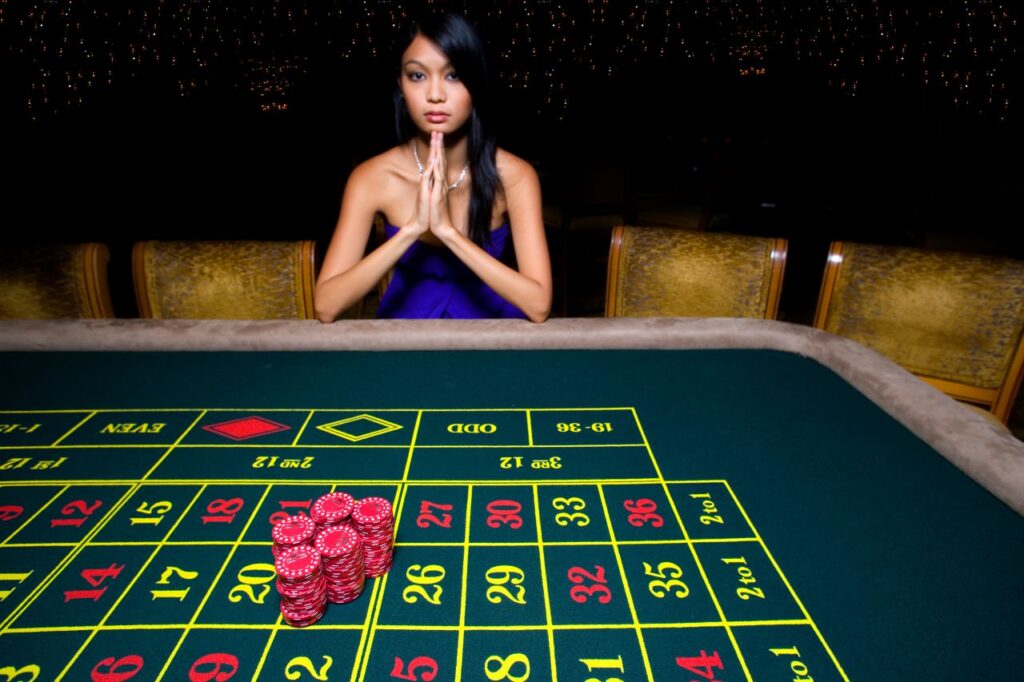 macau’s casino woman sitting at the roulette table with no customers