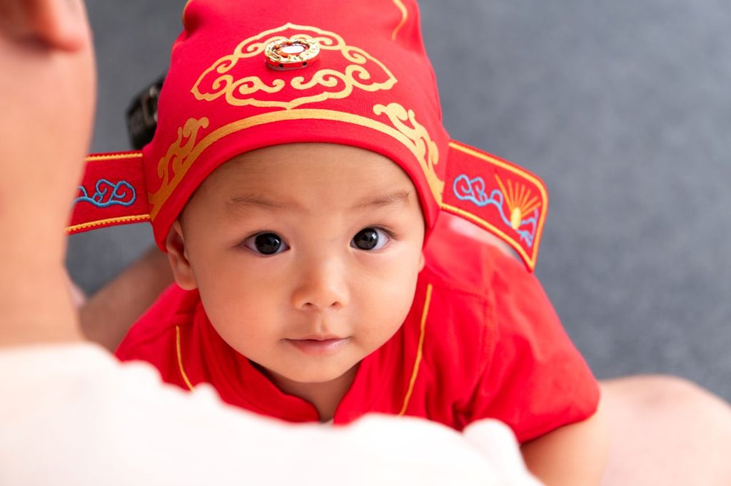 baby china wearing a red ornamental hat